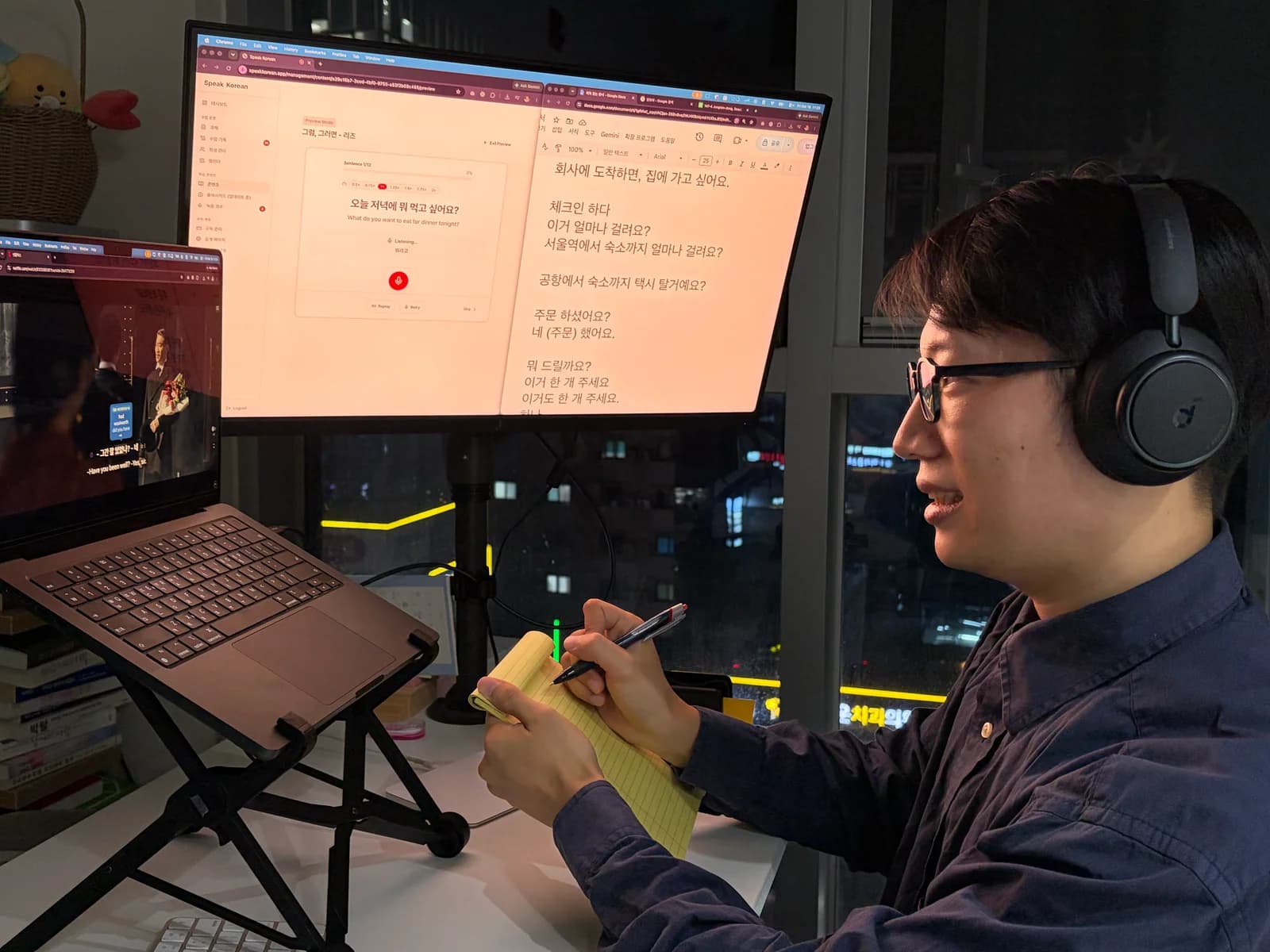 Practicing Korean at a desk with a drama scene, speaking exercises, and handwritten notes